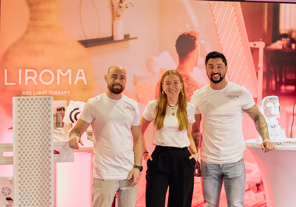 Het team van Liroma bij de stand met een roodlichtpaneel
