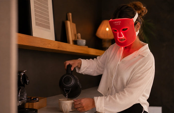 Persoon ontspant met het Liroma GLOW led masker voor rood licht therapie